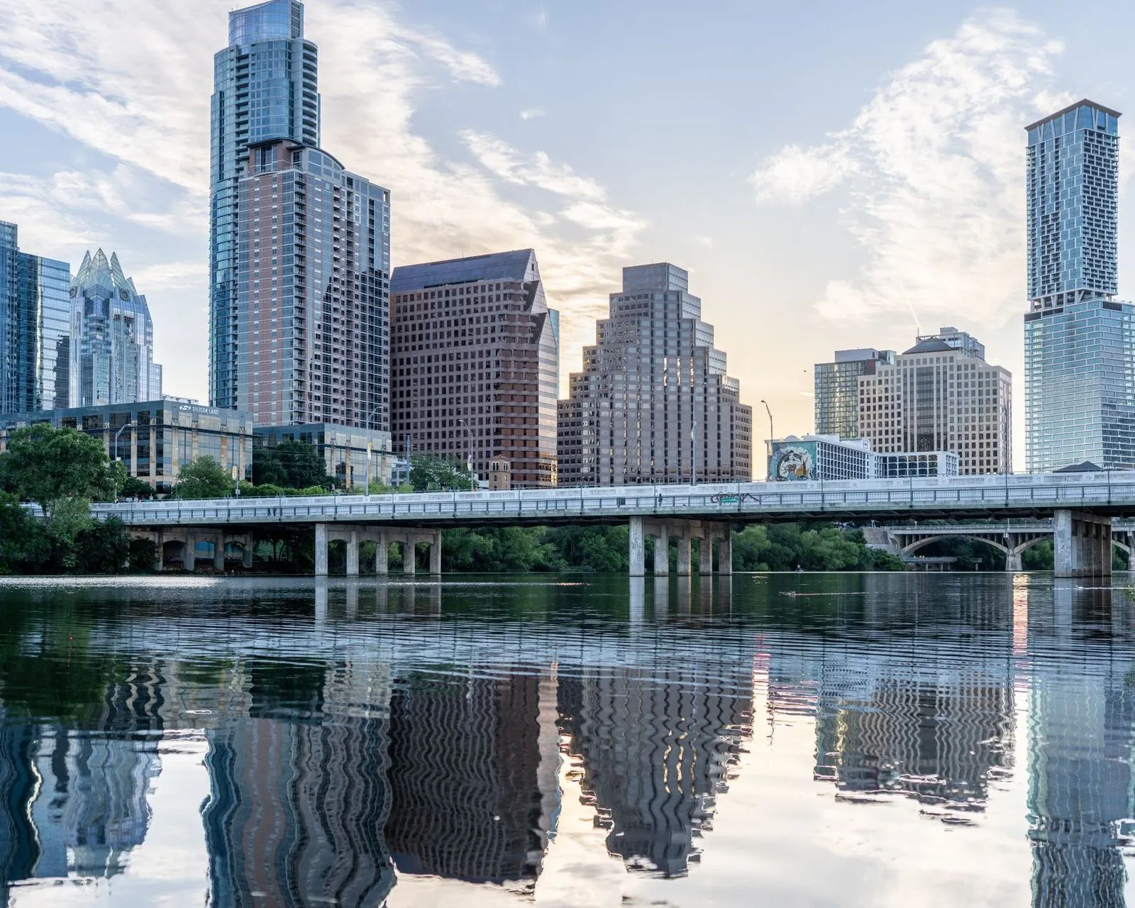 The Austin skyline behind a road bridge over the river