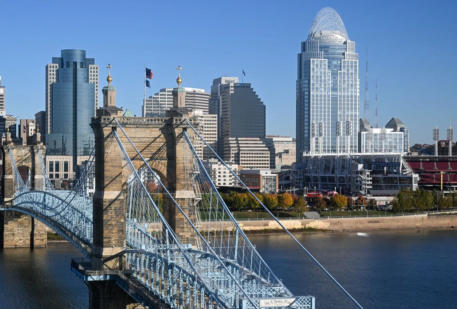 A suspension bridge over the Ohio River with the Cincinnati skyline behind it