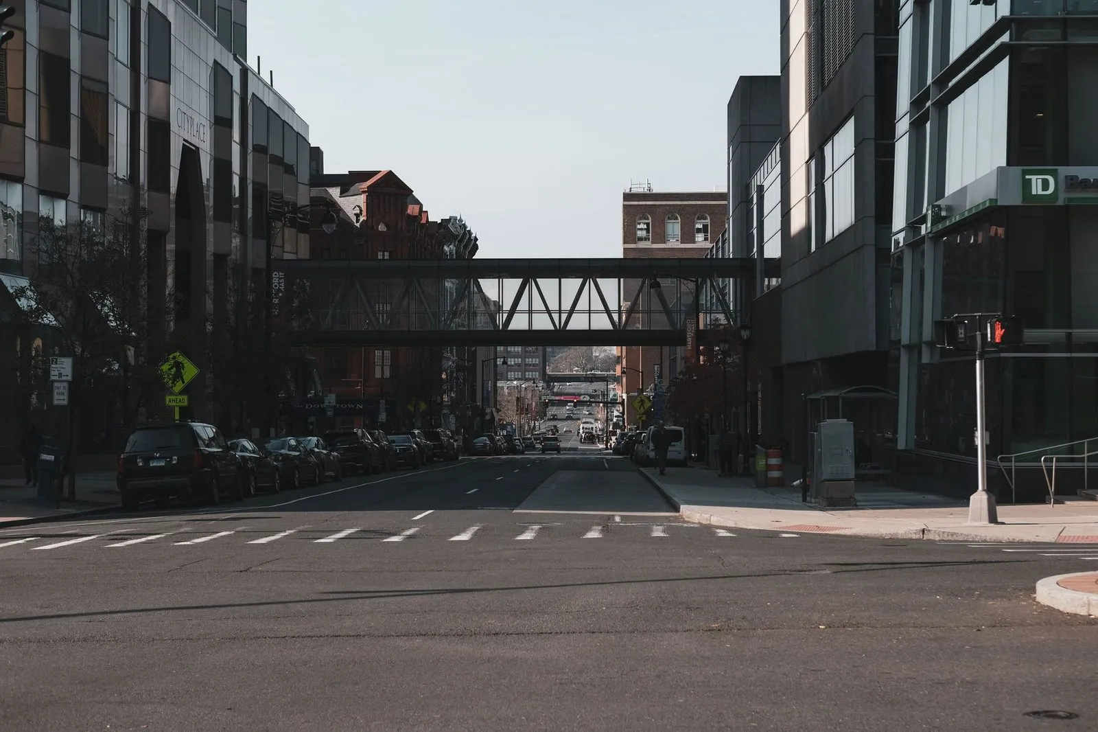 A downtown Hartford street with an enclosed skywalk crossing above it