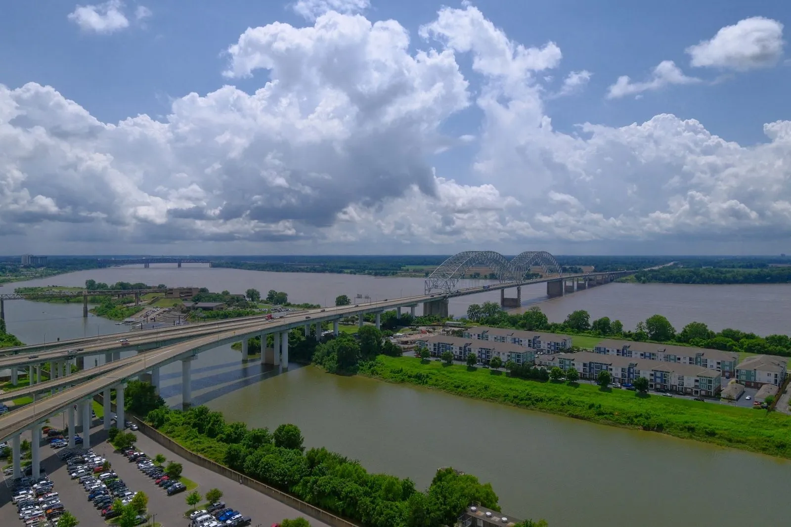 An M-shaped bridge over the Mississippi with the Memphis skyline behind it