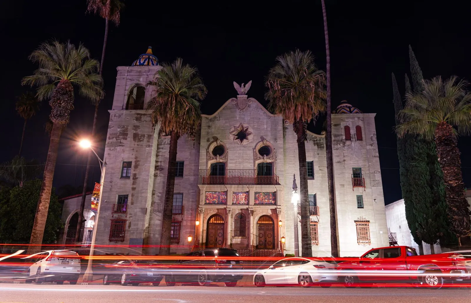 A domed civic auditorium in Riverside behind a row of tall palms